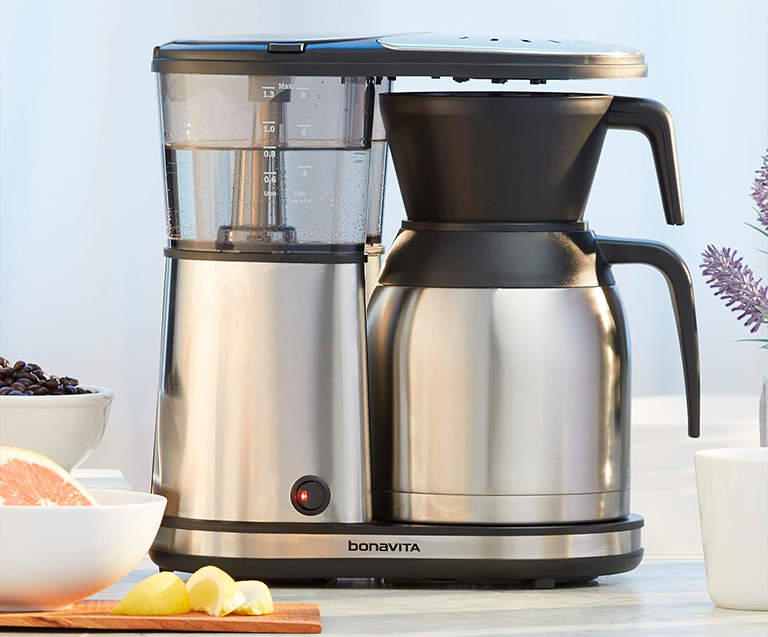 a coffee maker with a bowl of fruit